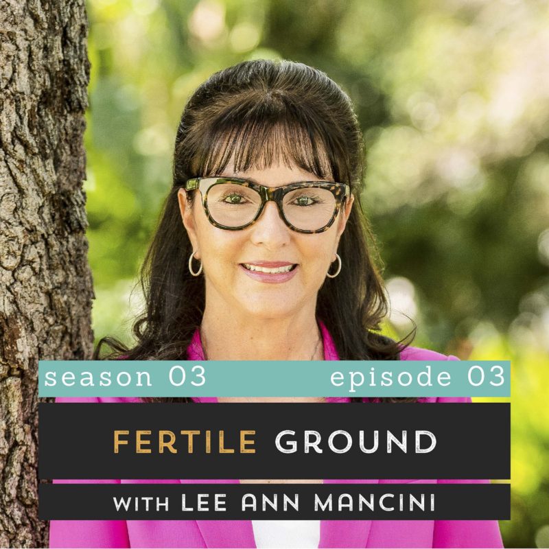 The Pantry Podcast - S03E03 - Fertile Ground with Lee Ann Mancini (Lee Ann smiling, leaning against tree, wearing pink blazer and white top)